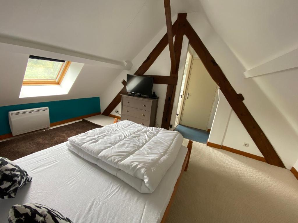 1 dormitorio con 1 cama blanca en el ático en Appartement village médiéval, en Parnac