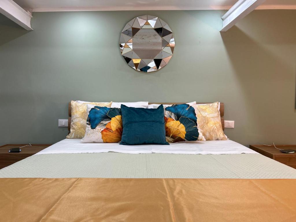 ein Bett mit Kissen und einem Spiegel an der Wand in der Unterkunft Casa Elivì Ballaró 2 passi dal centro storico, parcheggio e stazione ferroviaria in Palermo