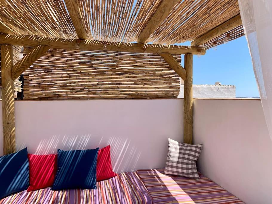Habitación con cama con almohadas coloridas. en Townhouse in Canillas de Aceituno en Canillas de Aceituno