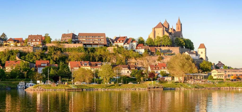 a town on a hill next to a body of water at Mobil Home Cosi Climatisé pour 6 - Camping Tohapi in Vogelgrun