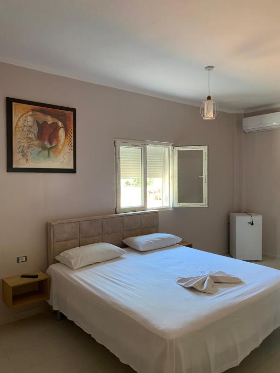a bedroom with a large white bed with two pillows at Blu Horizon Hotel Gjipe in Dhërmi