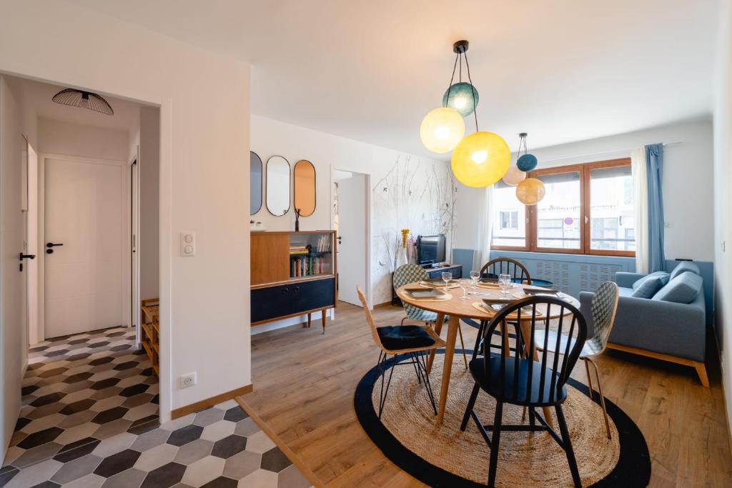comedor y sala de estar con mesa y sillas en Les Hirondelles - Appartement 3 chambres à Annecy, en Annecy