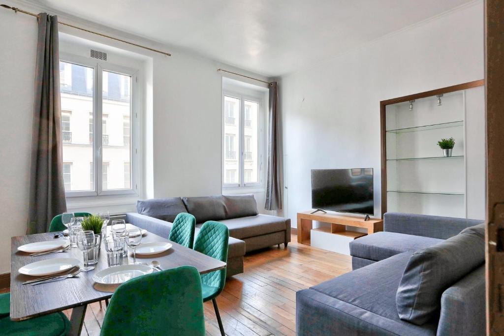 a living room with a table and a couch at Appartement Quartier Champs-Élysées in Paris