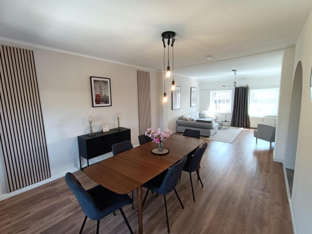 a dining room and living room with a table and chairs at Lofty Maisonette Wohnung, A Lage, Messenähe in Essen