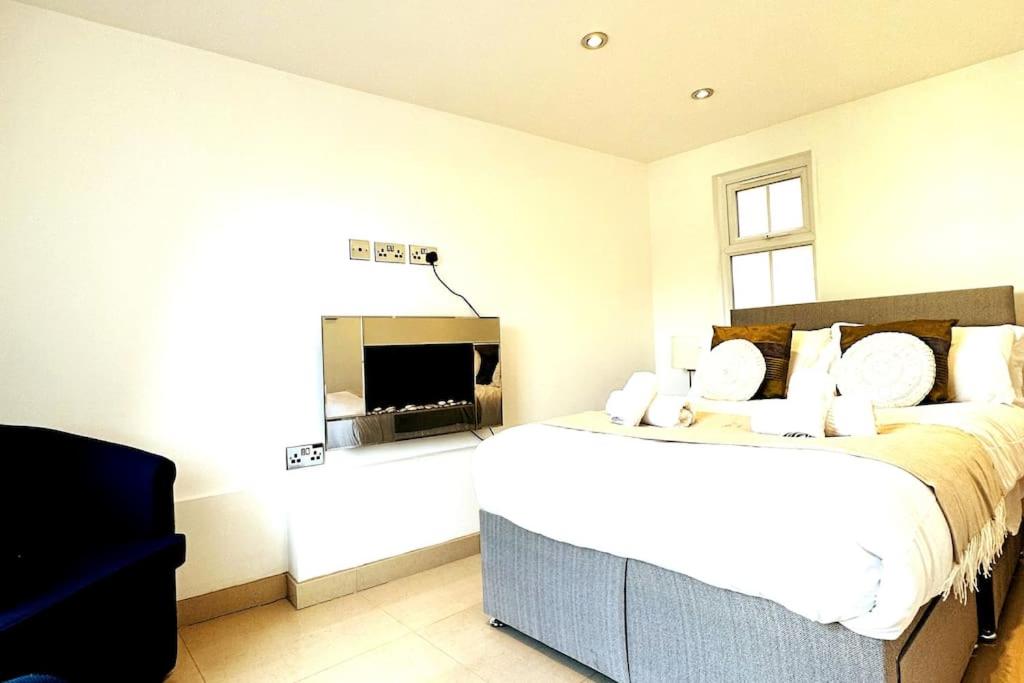 a bedroom with a large bed and a fireplace at Smithfield St Paul Farringdon Central London Apartment in London