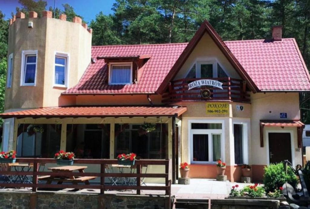 una casa con techo rojo y mesa de picnic en Róża Wiatrów, en Sztutowo