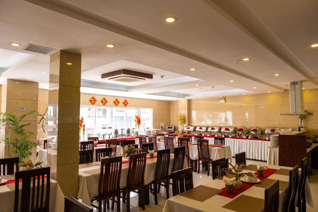 a restaurant with tables and chairs in a room at Gem Nha Trang Hotel in Nha Trang