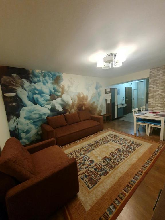 a living room with a couch and a painting on the wall at Forest Apartments in Sinaia