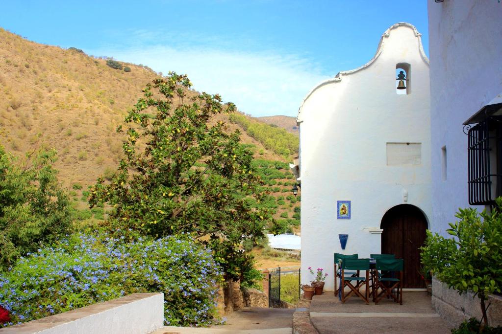AlbuñolにあるLa Casita Azul - Casa típica andaluzaの小さな白い建物(テーブルと椅子付)