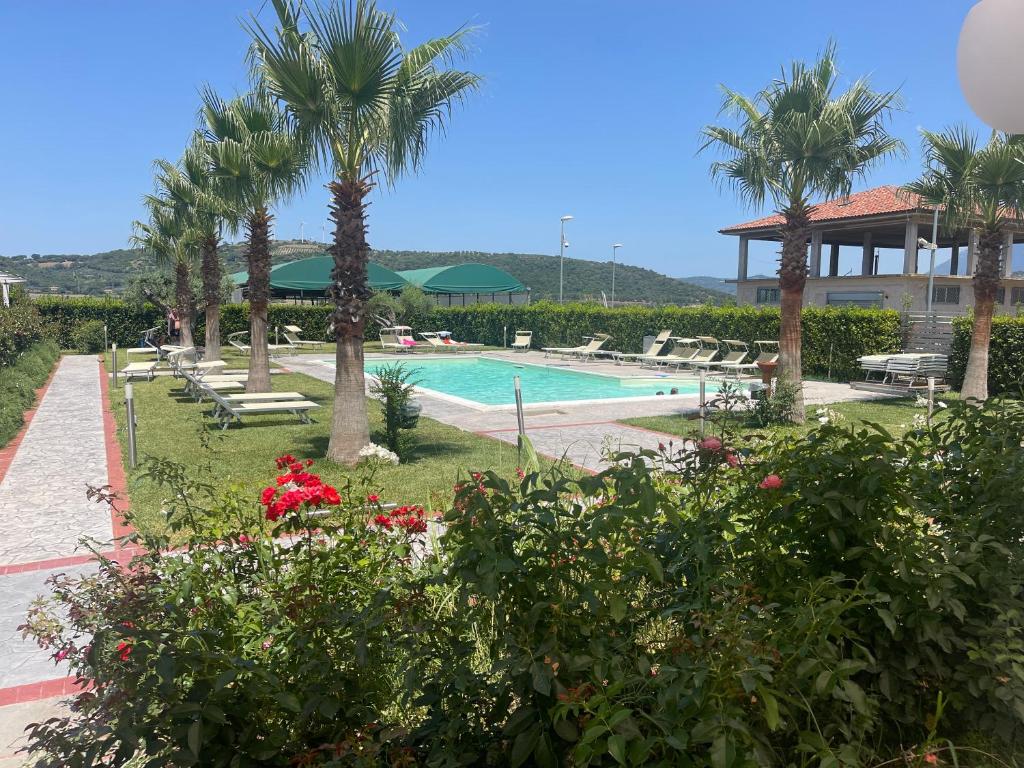 un resort con piscina e palme di Agriturismo San Raphael a Capaccio-Paestum