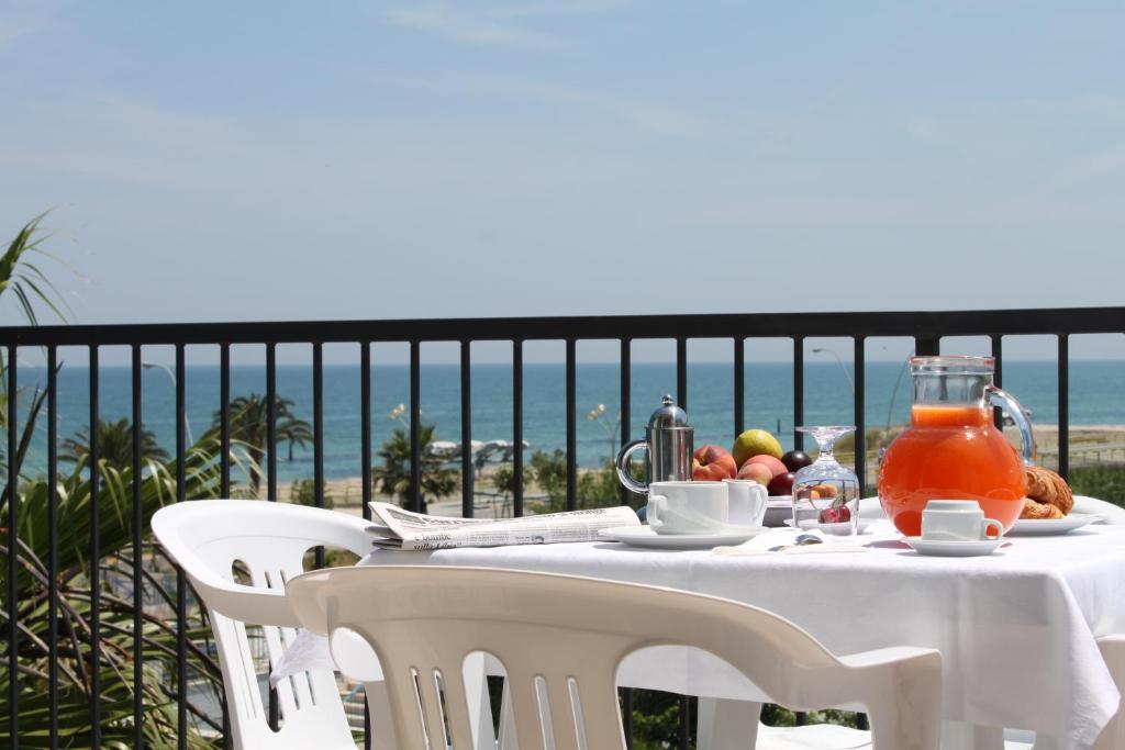 una mesa con comida y bebida en un balcón con vistas al océano en Residence Ada, en Grottammare