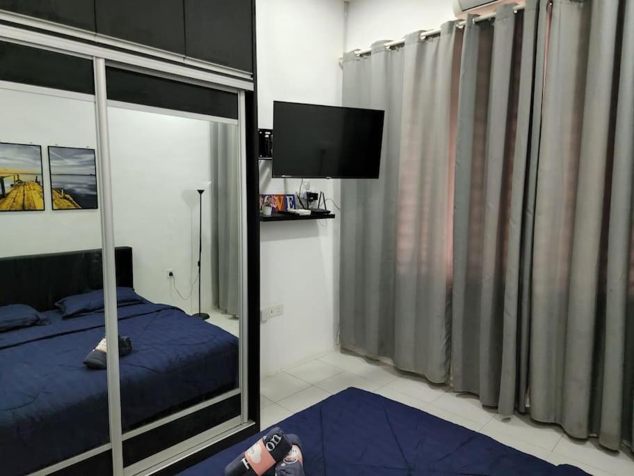瓜拉立卑的住宿－Hud D'Lipis Homestay，一间带镜子、一张床和电视的卧室