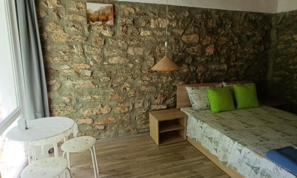 Un dormitorio con una cama con almohadas verdes y una mesa. en Granichar 3 Surfa, en Granichar