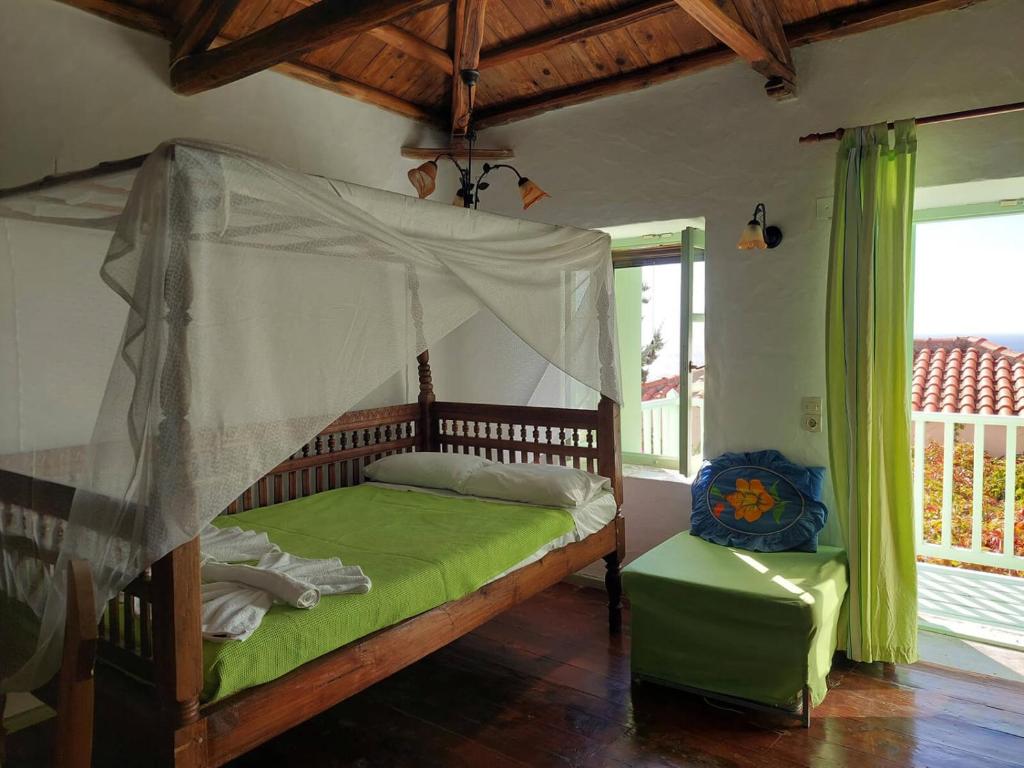 a bedroom with a bed with a mosquito net at Elma's Houses - Green House Yanna in Alonnisos
