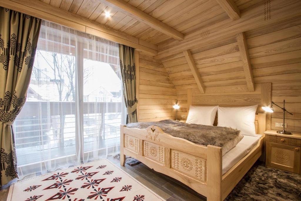 sypialnia z łóżkiem i dużym oknem w obiekcie Willa Tatiana Boutique w Zakopanem