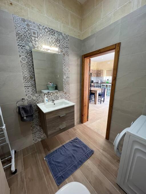 bagno con lavandino, specchio e servizi igienici di Ta' Cikku Farmhouse a Xagħra
