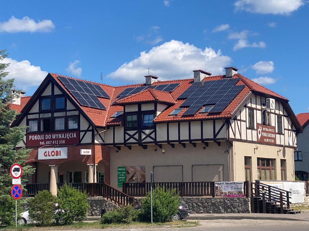 a building with solar panels on top of it at Pokoje Gościnne Stawiguda in Stawiguda