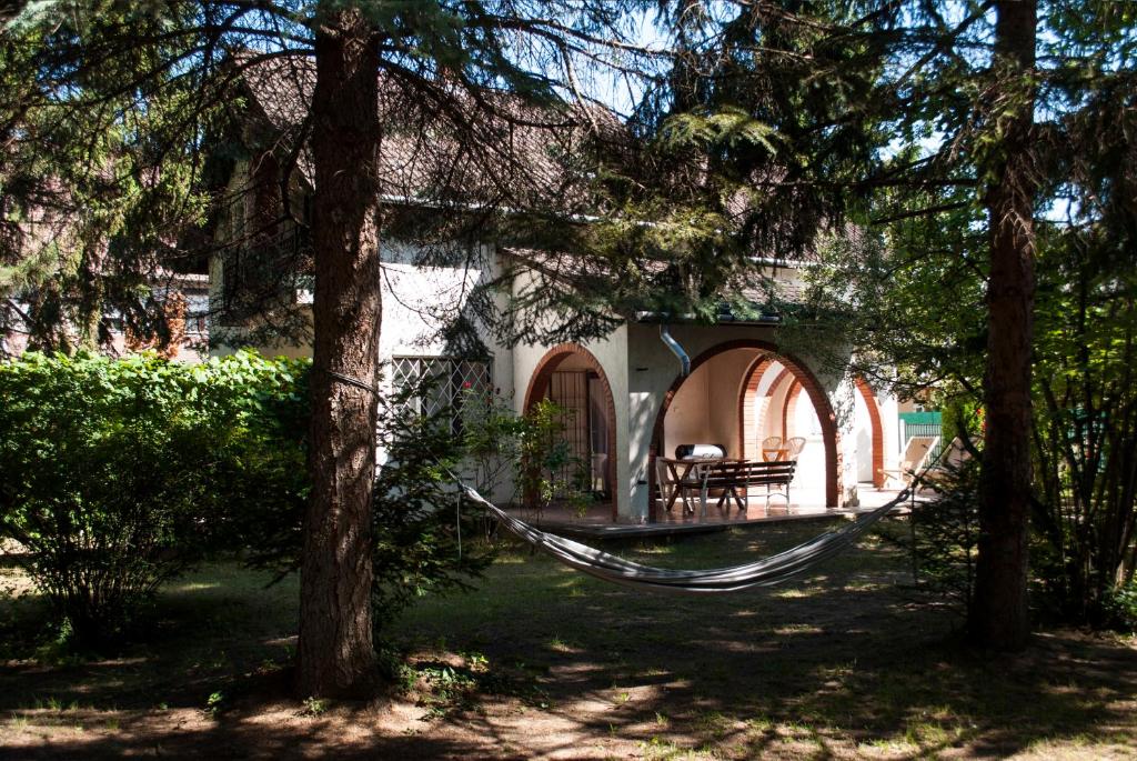 a hammock in front of a house with trees at Endretro Apartments in Siófok