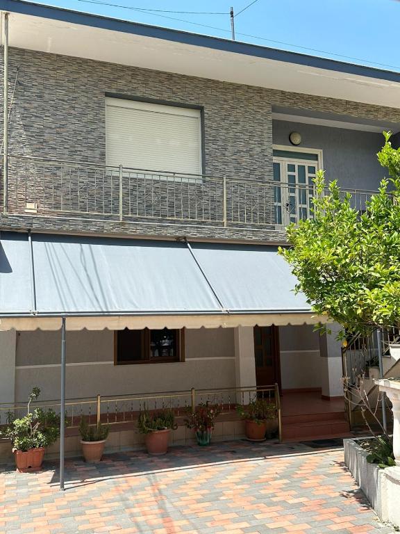 a building with awning and a balcony with plants at Vila Adriatik 1 in Vlorë