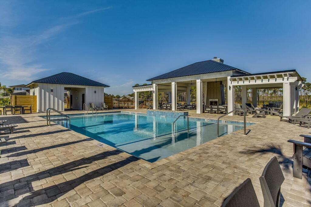 a swimming pool in a patio with a building at Modern Luxury 4BR Pool Bay Access Outdoor Dining in Pensacola