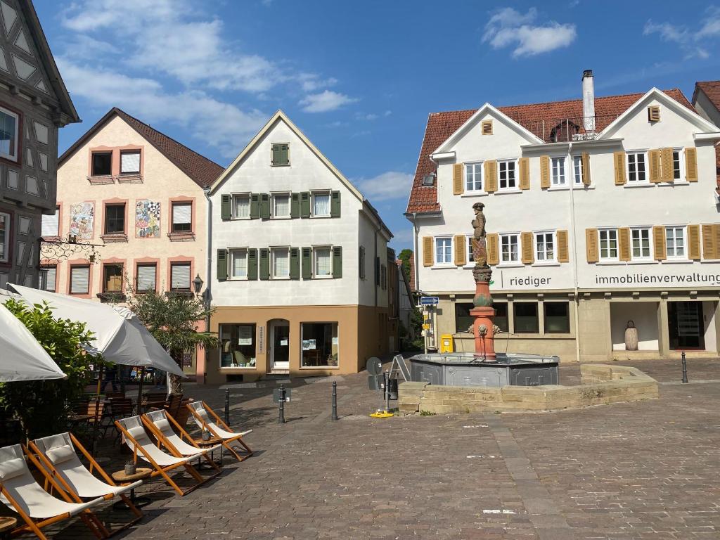 um grupo de cadeiras sentadas num pátio com edifícios em Marktblick-Besigheim em Besigheim