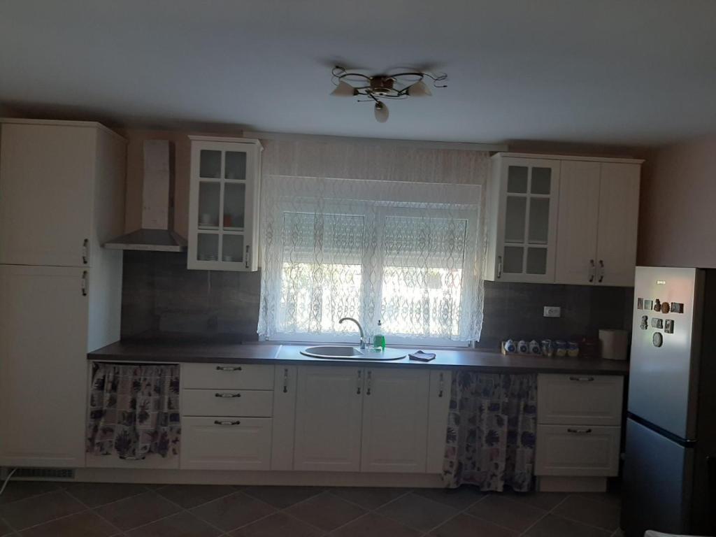a kitchen with white cabinets and a sink and a window at Sunny in Trnava