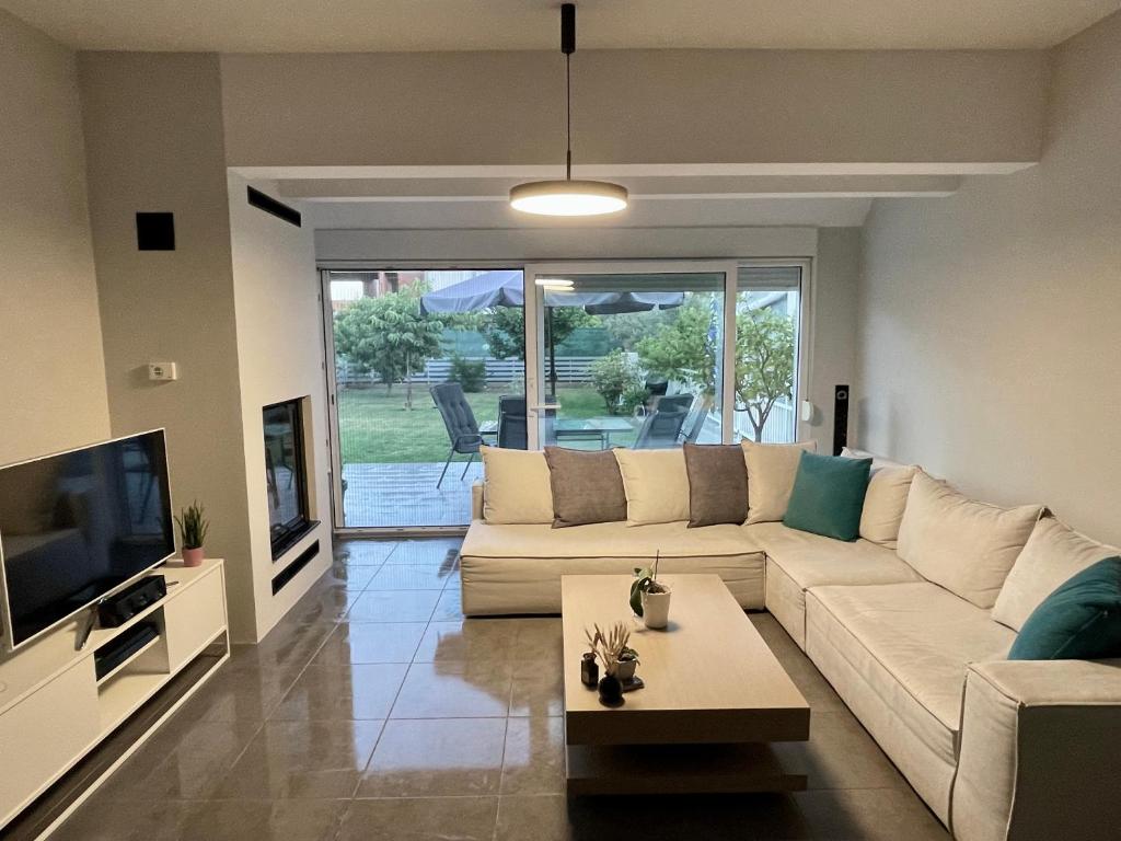 a living room with a couch and a tv at Villa Joanne in Alexandroupoli