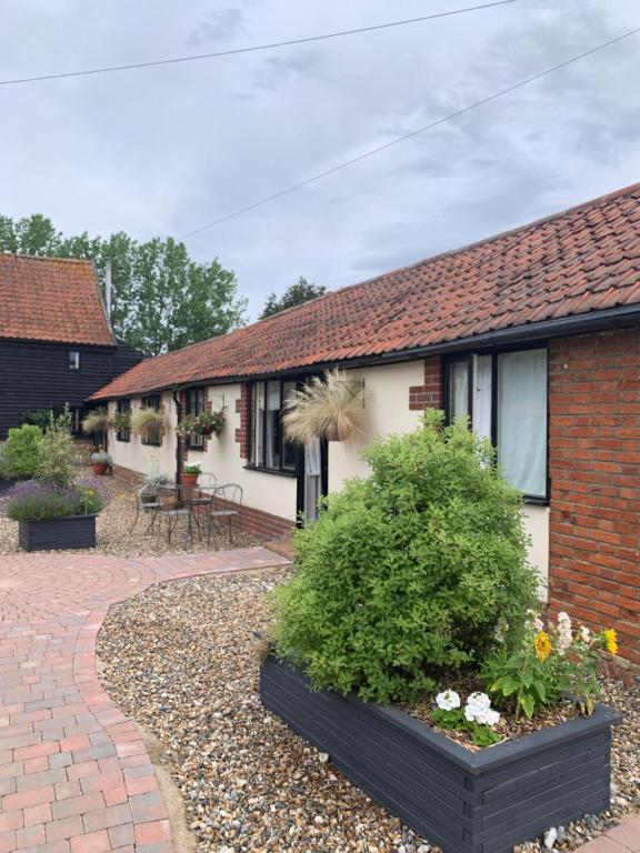 a house with a brick walkway in front of it at Bluebell Barn in Banham