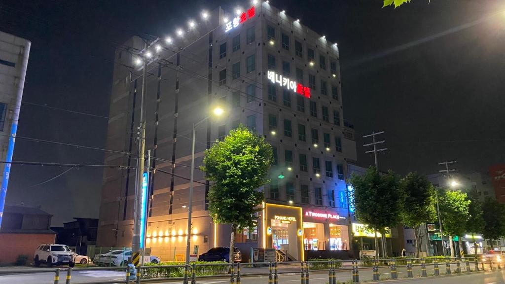 a tall building with a sign on the side of it at night at Benikea Hotel Pohang in Pohang