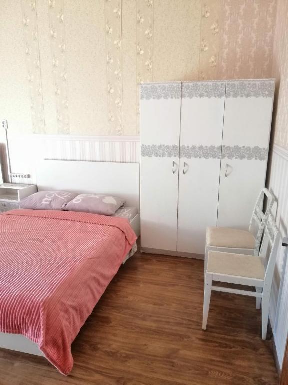 a bedroom with a bed and a cabinet and a chair at Ланжероновская угол Дерибасовская in Odesa