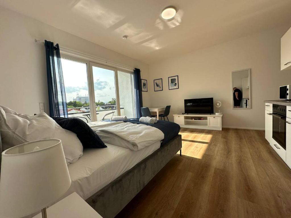 een slaapkamer met een groot bed en een televisie bij SUITE4ME - Balkon I Küche I Waschmaschine I Mainz-Kostheim in Wiesbaden