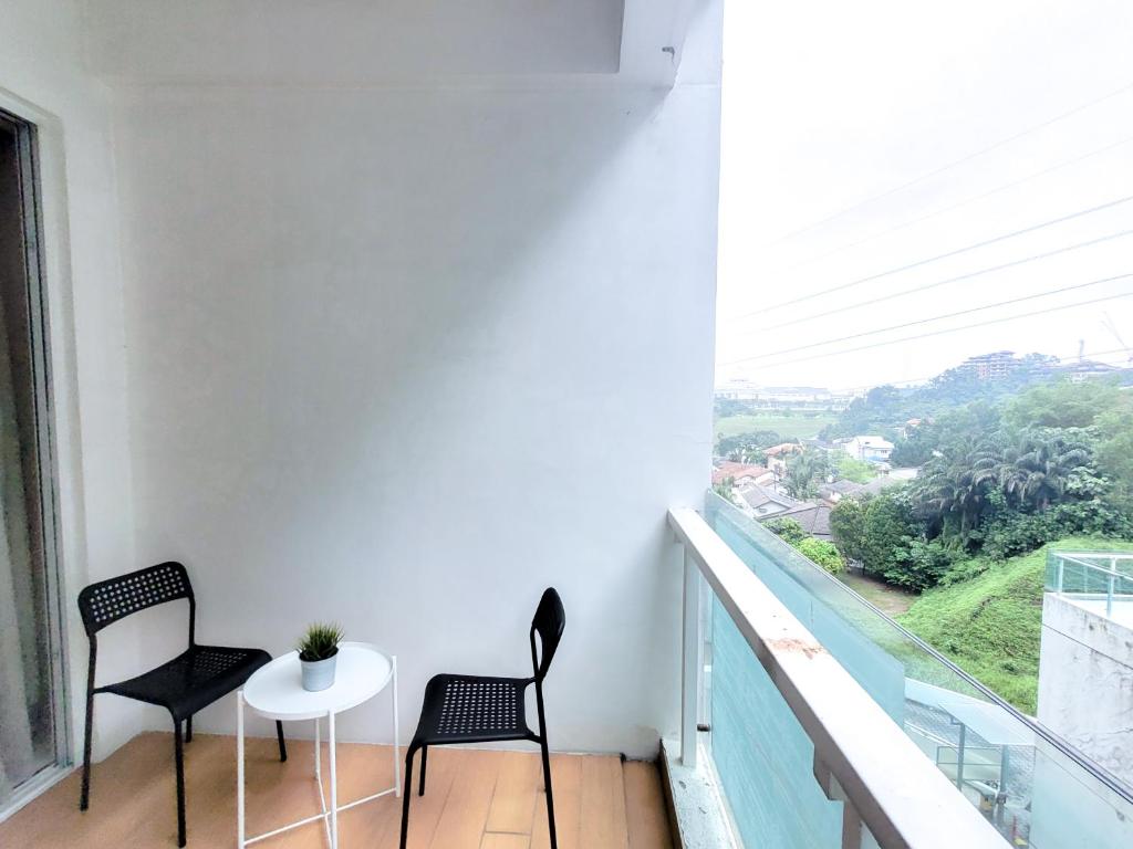 two chairs and a table on a balcony with a view at Damas Residence Kuala Lumpur in Kuala Lumpur