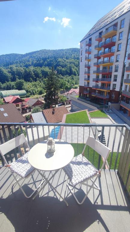 a white table and chairs on a balcony with a building at BELLE VIEW SINAIA-free parking in Sinaia