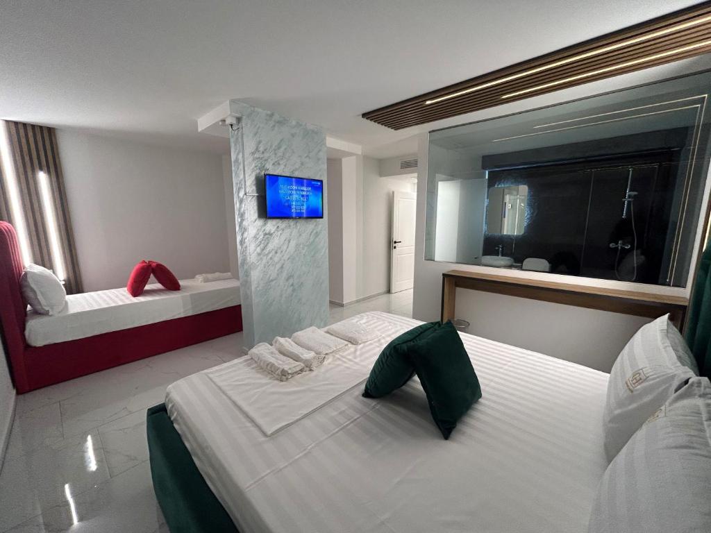 a bedroom with a large white bed and a tv at Comfort Hotel in Struga