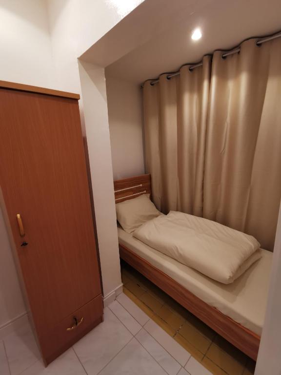 Habitación pequeña con cama y cortina en Cloud9 Premium Hostel en Dubái