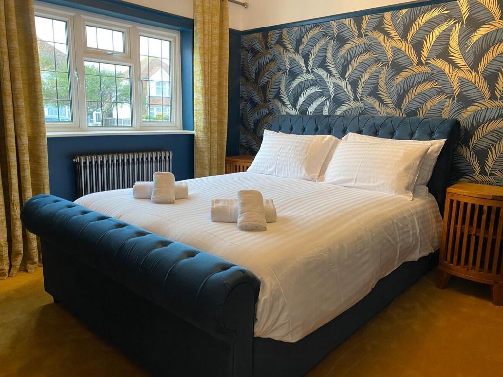 um quarto com uma cama grande e toalhas em Eclectic Bungalow Parking Nr Beach em Kent