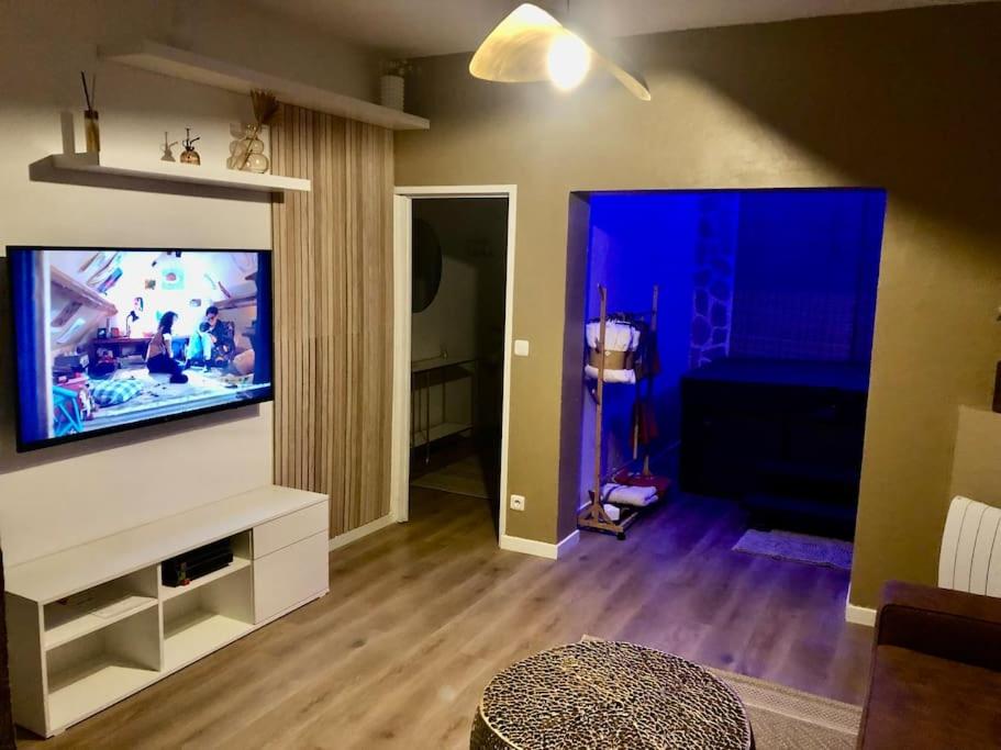 een woonkamer met een flatscreen-tv aan de muur bij L’oasis spa in Quiévrechain