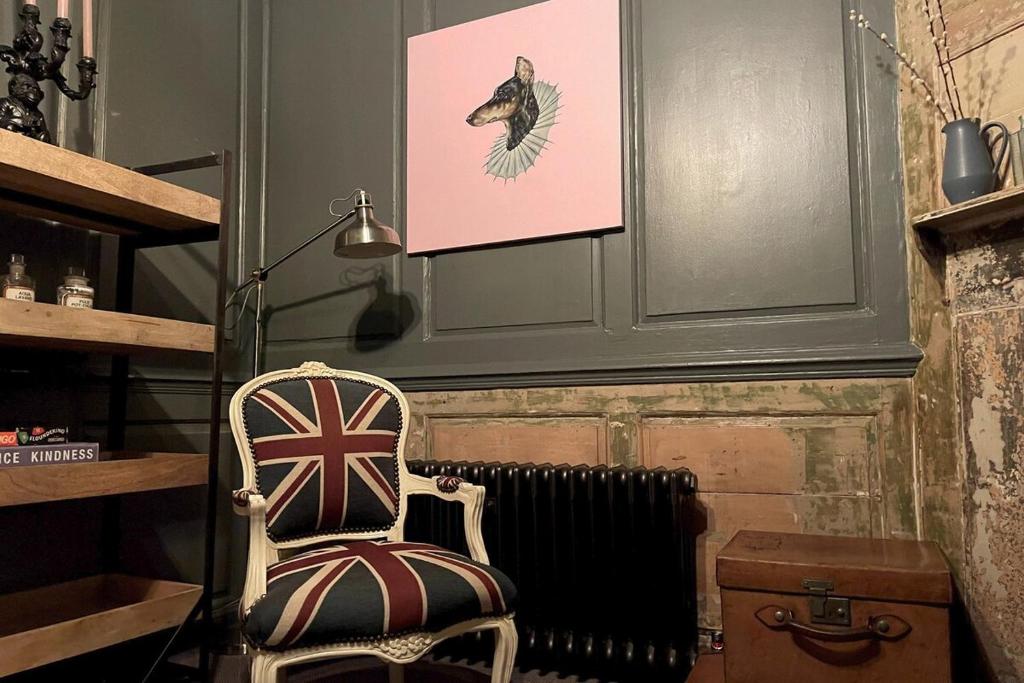 a room with a chair and a picture of a bird at Old Town Retreat, Grade Ii Listed, Margate Kent in Kent