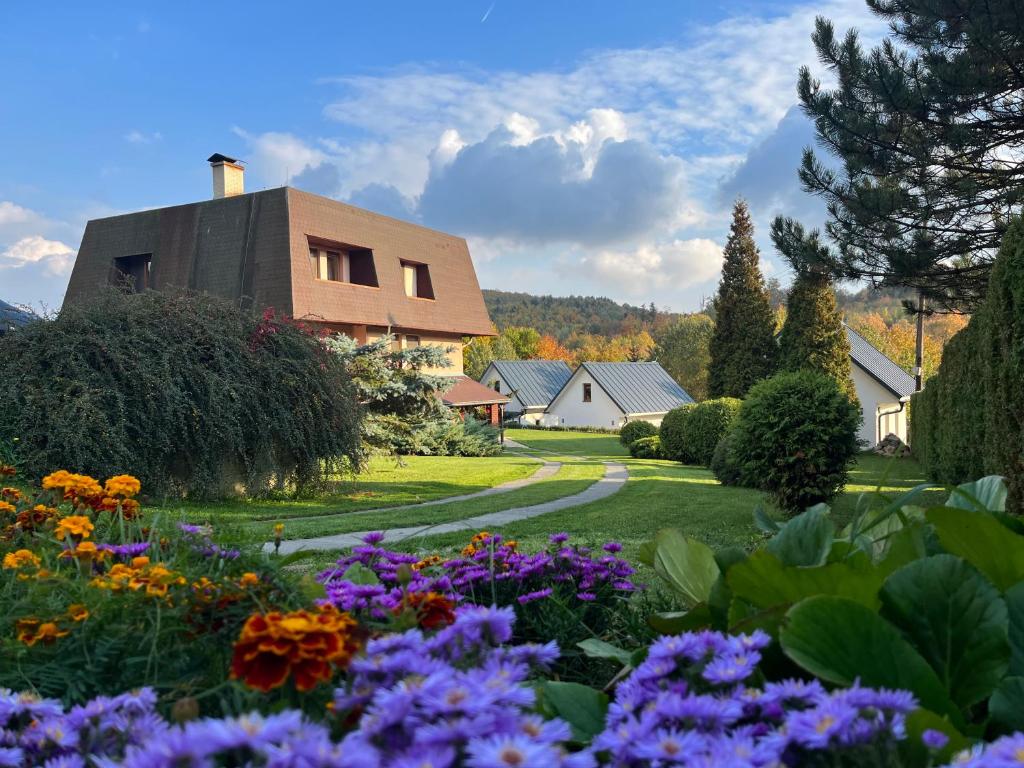 um jardim com flores em frente a uma casa em ubytovanie Vážka em Banská Štiavnica