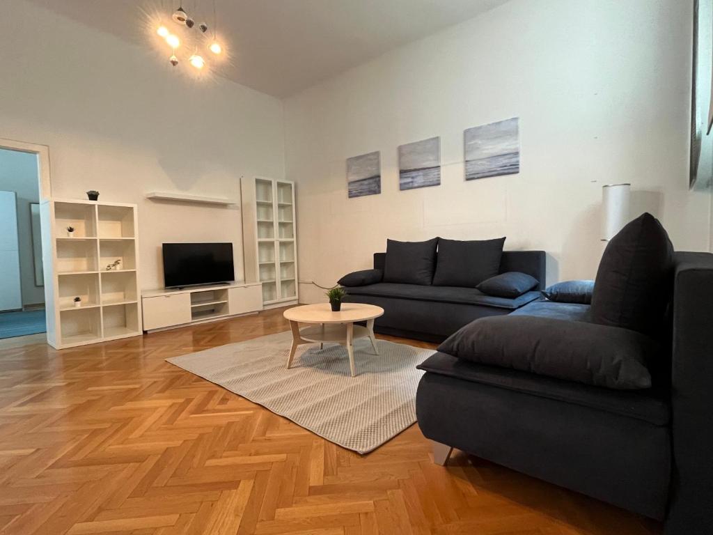 ein Wohnzimmer mit einem Sofa und einem Tisch in der Unterkunft Stylish Apt near Urania 1BR in Wien