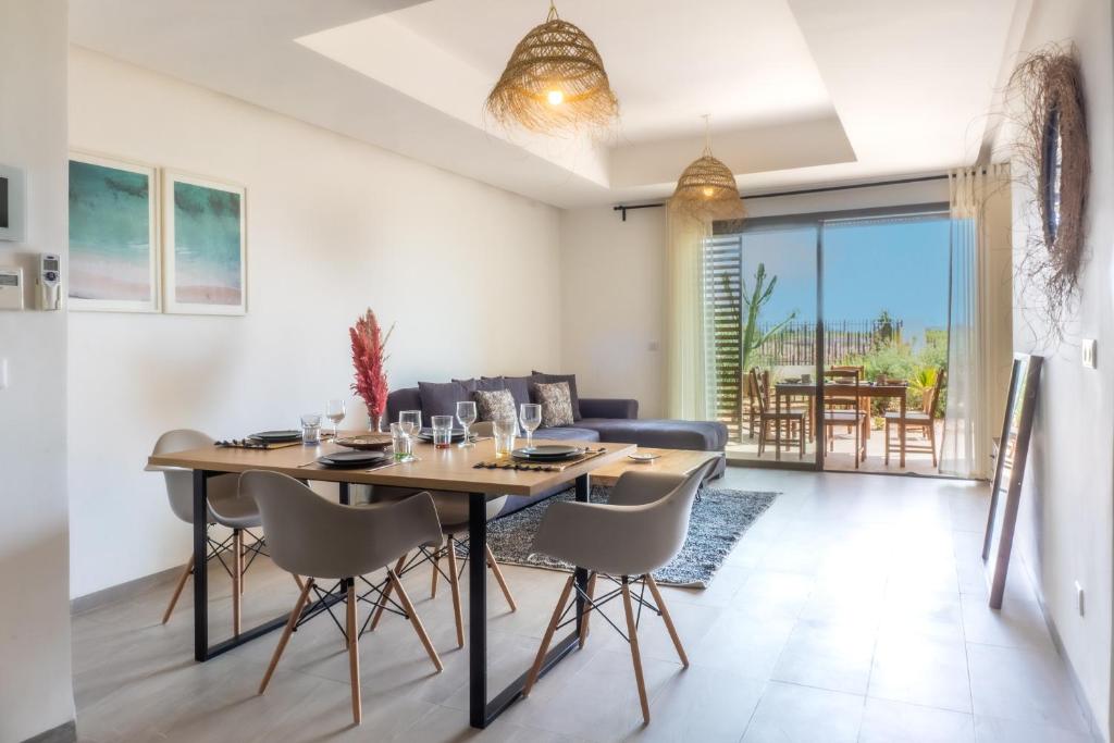 a dining room and living room with a table and chairs at Ijdi Taghazout - T3 Luxe - Piscine - 4 or 5 Px in Taghazout