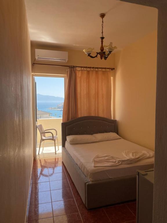 a bedroom with a bed and a window with a view at Hotel Gjika in Sarandë