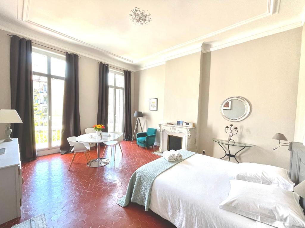 マルセイユにあるMaison Dormoyのベッドルーム(大きな白いベッド1台、テーブル付)
