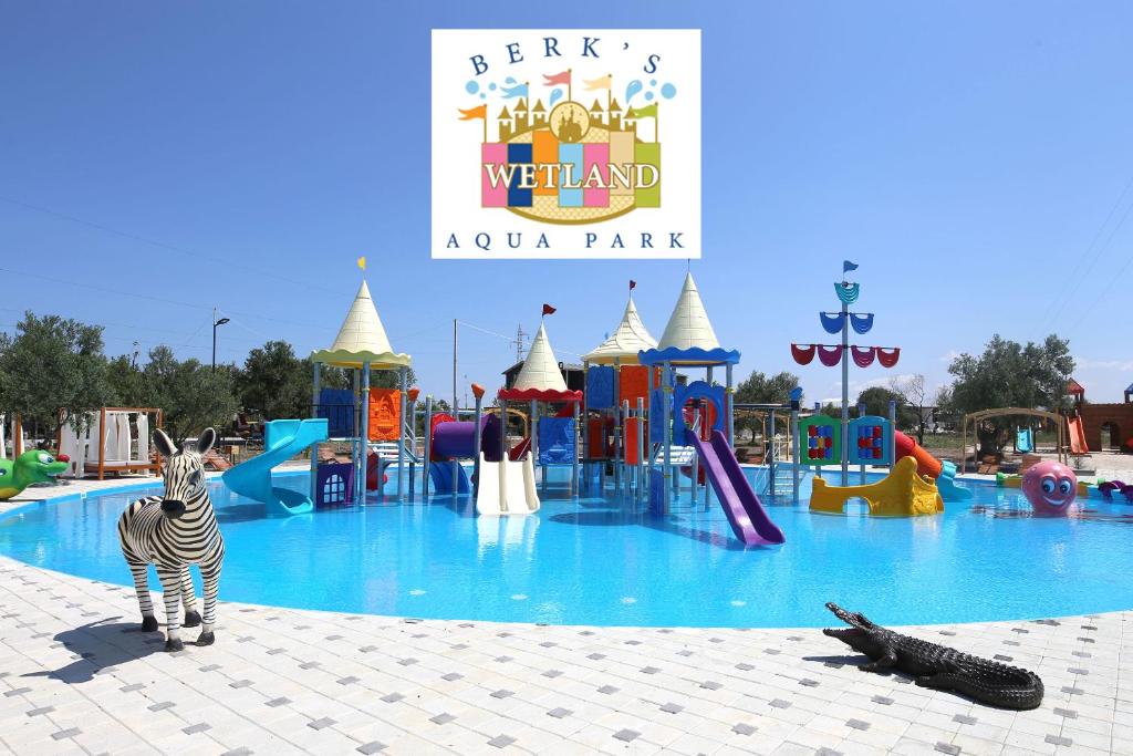 ein Zebra steht vor einem Wasserpark in der Unterkunft Simlarda Country Club Ayvalık in Ayvalık