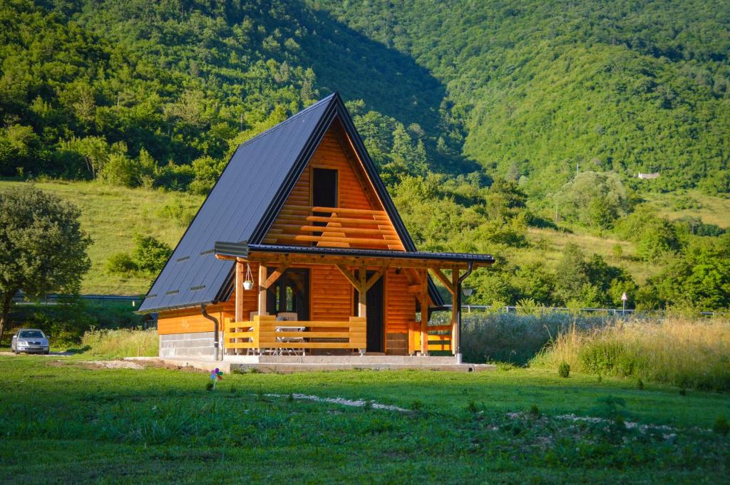 une grande cabane en bois avec un toit noir dans l'établissement Freedom in Forest, à Jajce