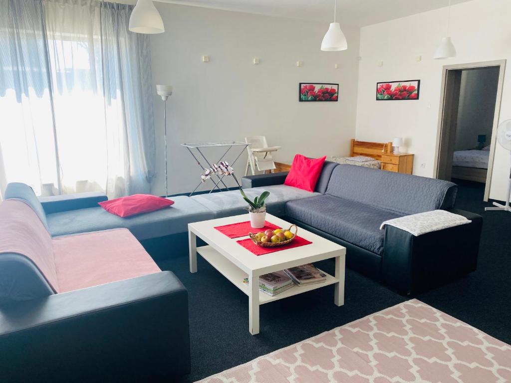 una sala de estar con 2 sofás azules y una mesa. en Apartmány Superrelax, en Liptovský Mikuláš