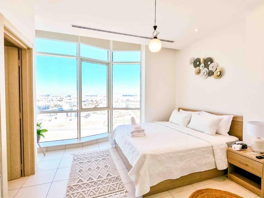 a bedroom with a white bed and a large window at Chic/Elegant 4 Bedrooms… in Jeddah