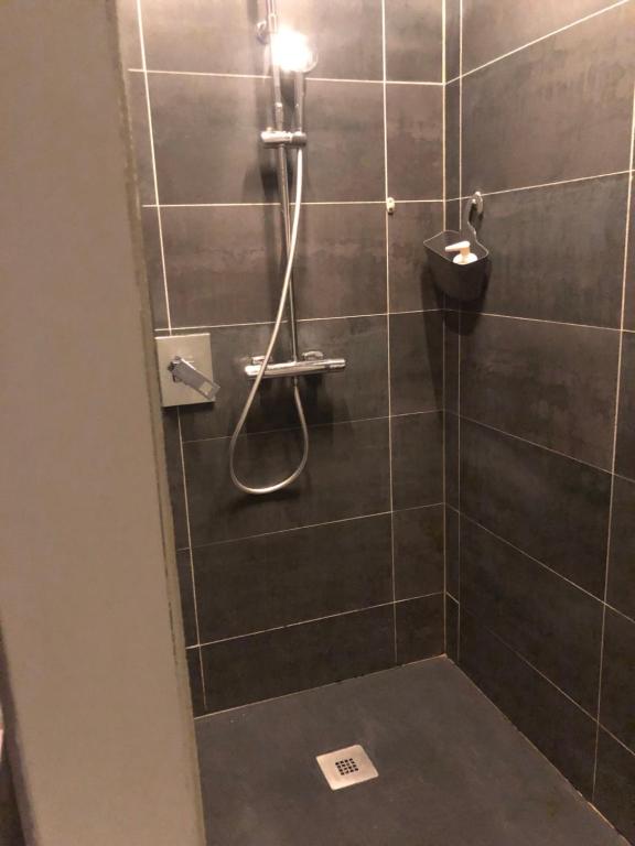 a bathroom with a shower with a shower head at Au bout du pré in Pézenas