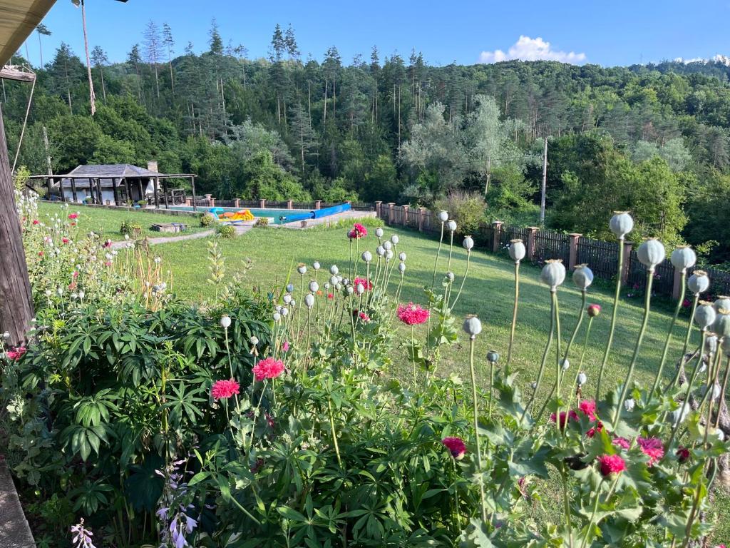 a garden with flowers and a pool in the background at FarFar Hideaway in Tryavna