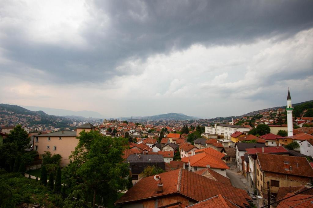 a view of a city with roofs and a cloudy sky at View in Sarajevo